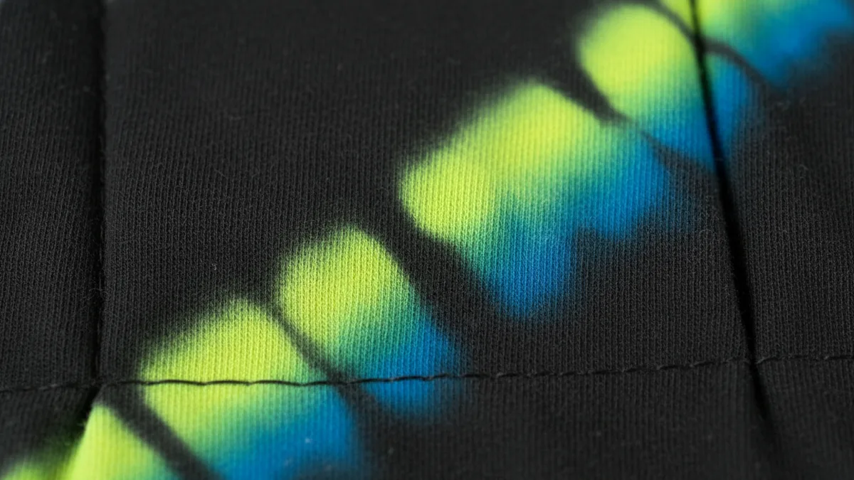 Color removal contrast on cotton Close view of cotton where bleach has removed dye to form light tie dye streaks.