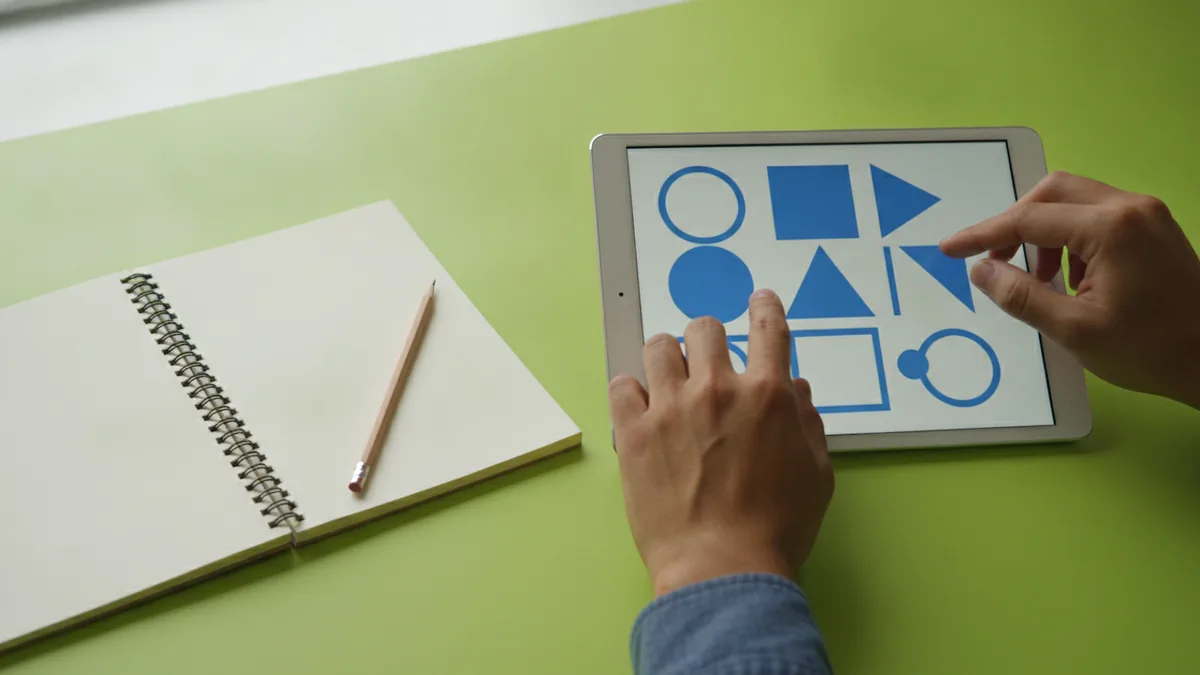 Hands refining simple logo shapes during a logo design process